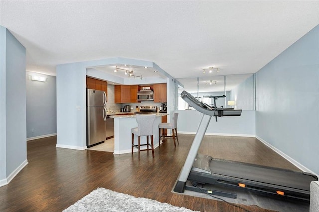 exercise area with dark hardwood / wood-style floors and a textured ceiling