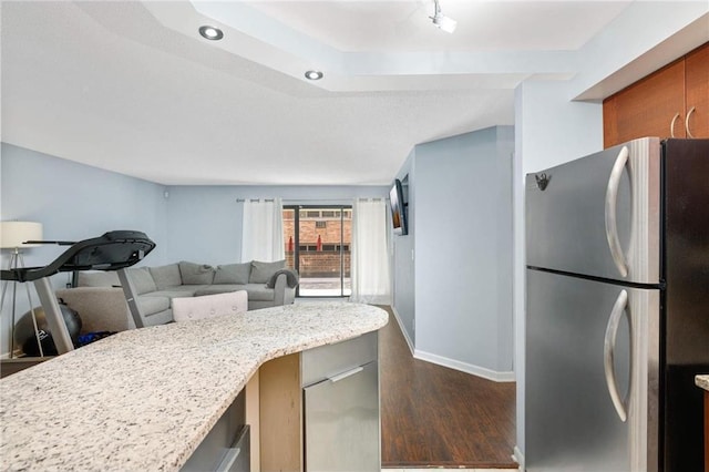 kitchen featuring stainless steel refrigerator, light stone countertops, and dark hardwood / wood-style flooring