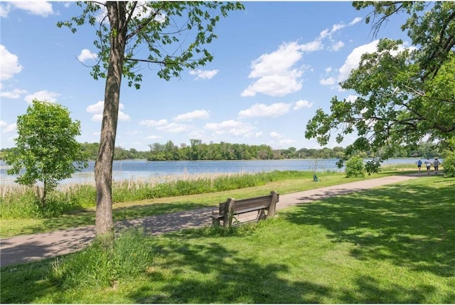 view of home's community with a lawn and a water view