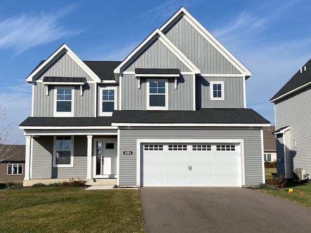 view of front of home featuring central AC, a front yard, and a garage