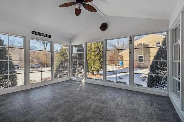 unfurnished sunroom featuring vaulted ceiling, ceiling fan, and plenty of natural light