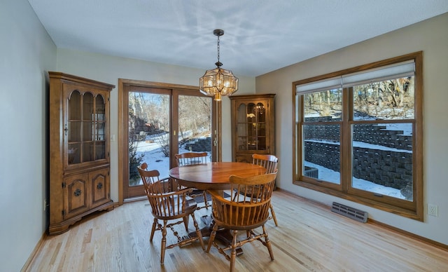 dining space with a notable chandelier and light wood-type flooring