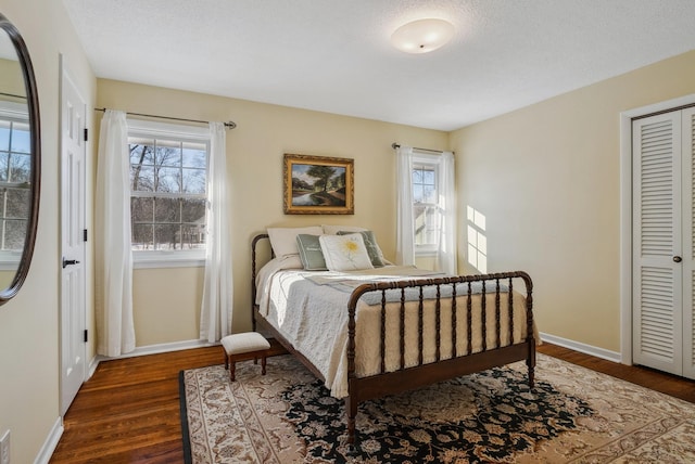 bedroom featuring a closet, dark hardwood / wood-style flooring, and a textured ceiling