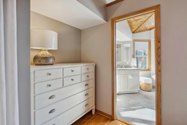 interior space with lofted ceiling, sink, and light hardwood / wood-style floors