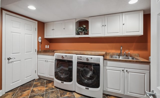 washroom with separate washer and dryer, sink, and cabinets