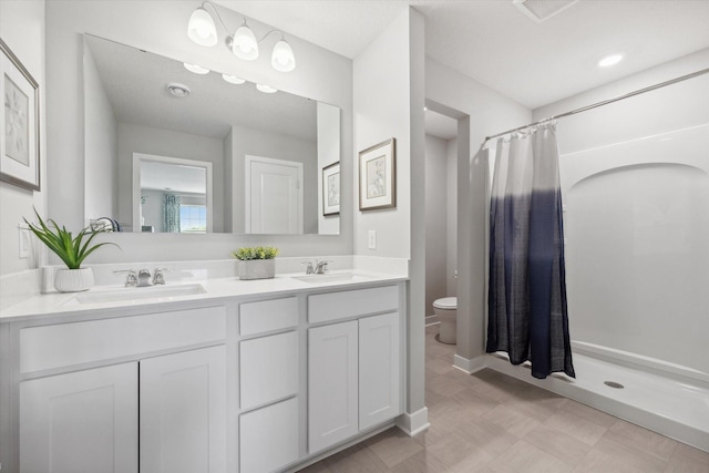 bathroom featuring vanity, toilet, and walk in shower