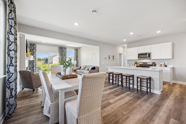 dining area featuring recessed lighting, wood finished floors, and baseboards