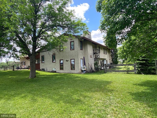 view of home's exterior featuring cooling unit and a yard