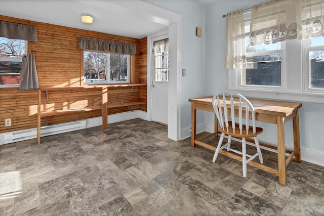 dining room with wooden walls and a baseboard radiator