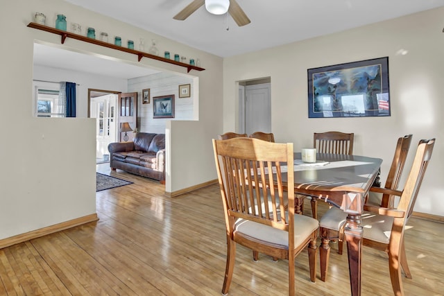 dining space with ceiling fan and light wood-type flooring