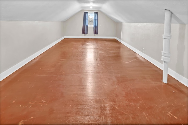 additional living space with hardwood / wood-style flooring and lofted ceiling