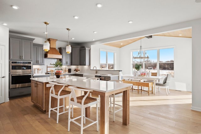 kitchen featuring decorative backsplash, a kitchen island, hanging light fixtures, and lofted ceiling