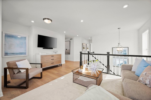 living room featuring light hardwood / wood-style floors and a notable chandelier