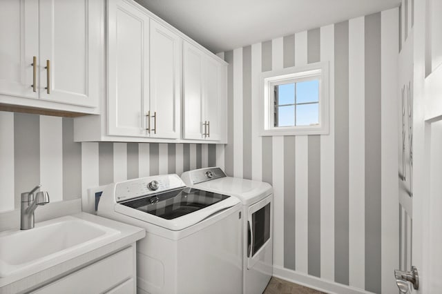 laundry area with cabinets, separate washer and dryer, and sink