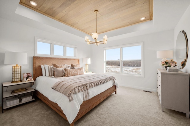 bedroom featuring wood ceiling, multiple windows, and a tray ceiling