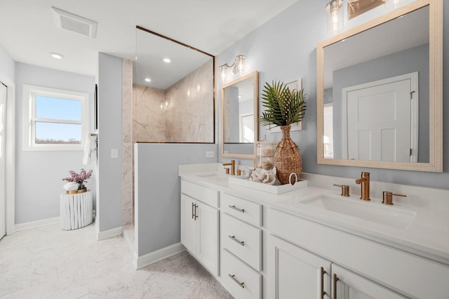 bathroom featuring a tile shower and vanity