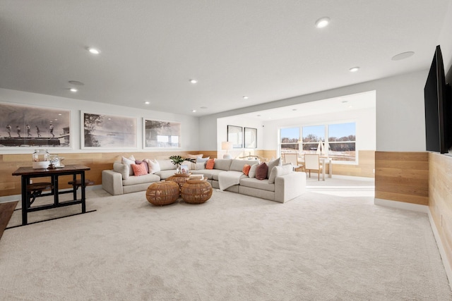 living room featuring light carpet and wood walls