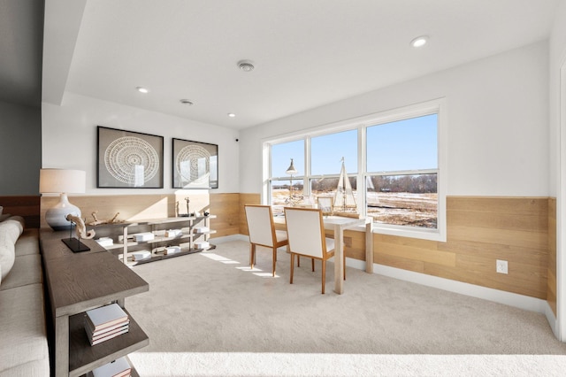 carpeted living room with wood walls