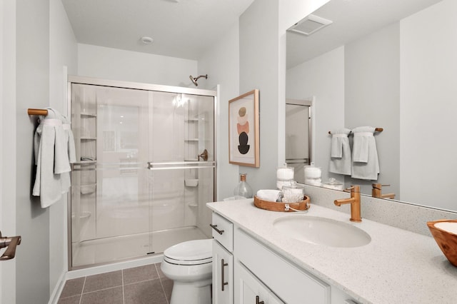 bathroom featuring tile patterned floors, a shower with door, vanity, and toilet