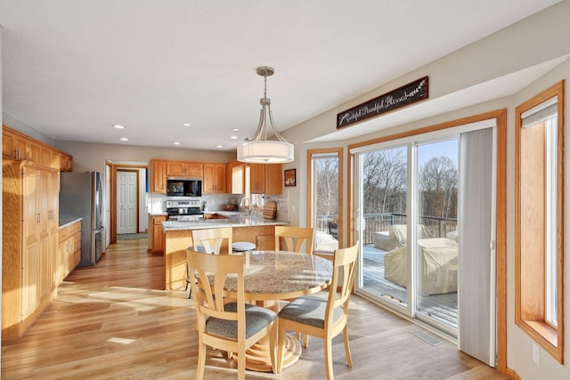 dining space featuring sink and light hardwood / wood-style floors