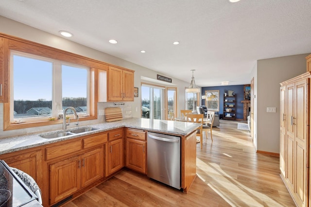 kitchen with pendant lighting, sink, stainless steel dishwasher, kitchen peninsula, and plenty of natural light