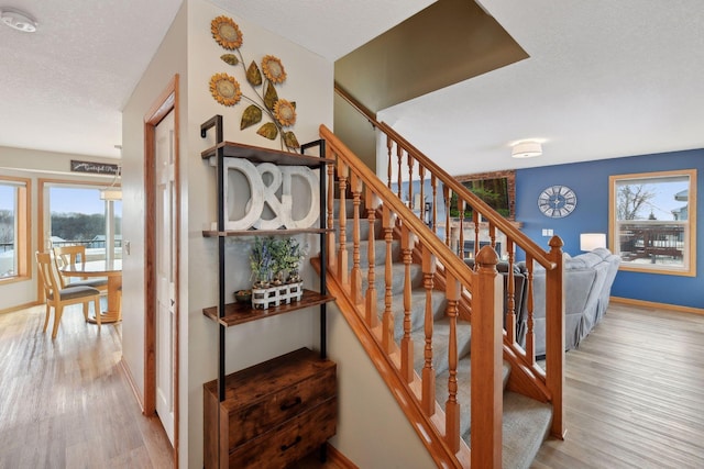 stairs with hardwood / wood-style floors and a textured ceiling