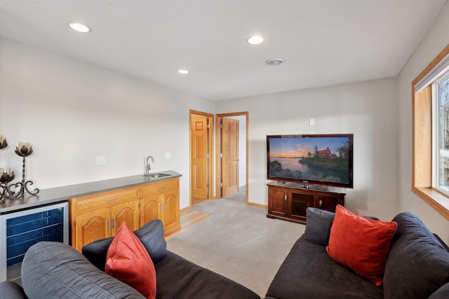 living room with light carpet, indoor wet bar, and beverage cooler