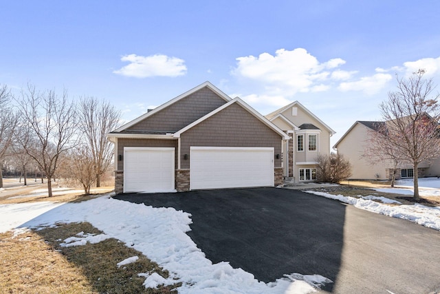 view of front of home with aphalt driveway, stone siding, and an attached garage