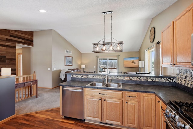 kitchen with visible vents, a sink, appliances with stainless steel finishes, dark countertops, and open floor plan