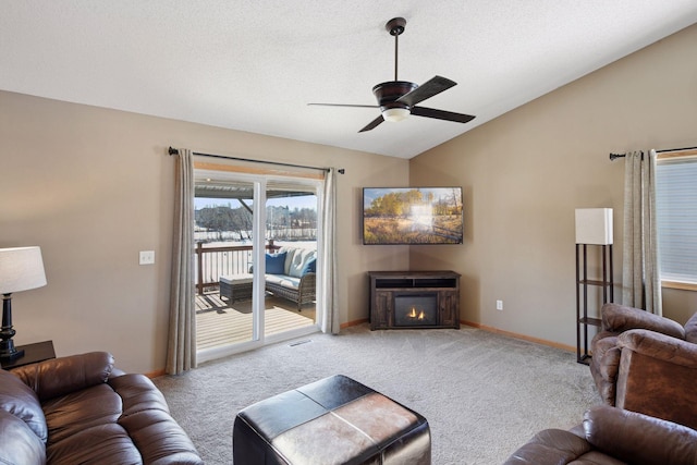 living area with carpet flooring, a warm lit fireplace, baseboards, and lofted ceiling