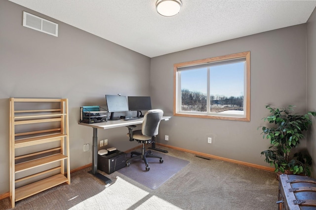 carpeted office space with visible vents, a textured ceiling, and baseboards