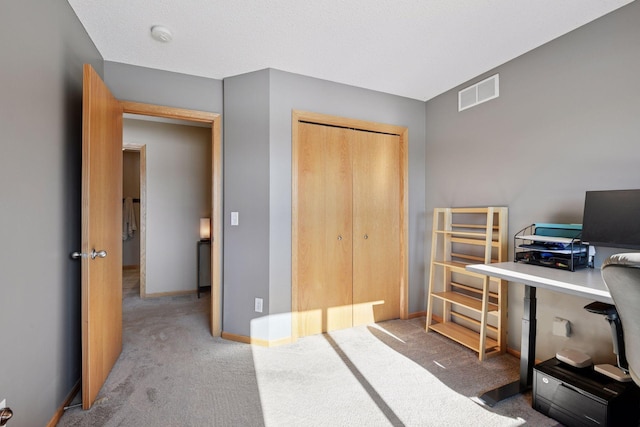 carpeted bedroom featuring visible vents, baseboards, and a closet