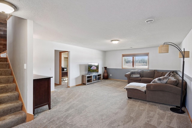 living area with stairway, baseboards, light colored carpet, and a textured ceiling