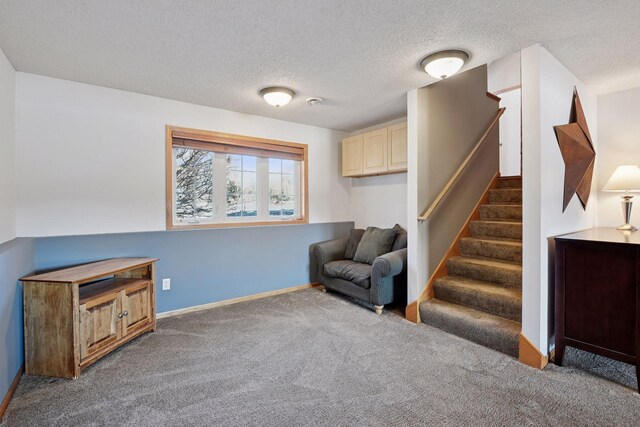 living area with carpet flooring, stairway, a textured ceiling, and baseboards