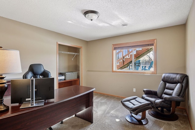 carpeted home office with a textured ceiling and baseboards