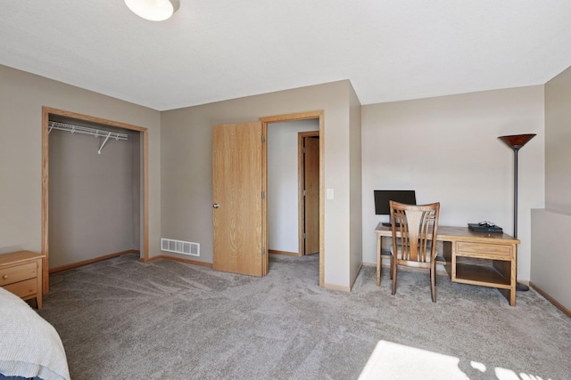 bedroom with a closet, visible vents, carpet flooring, and baseboards