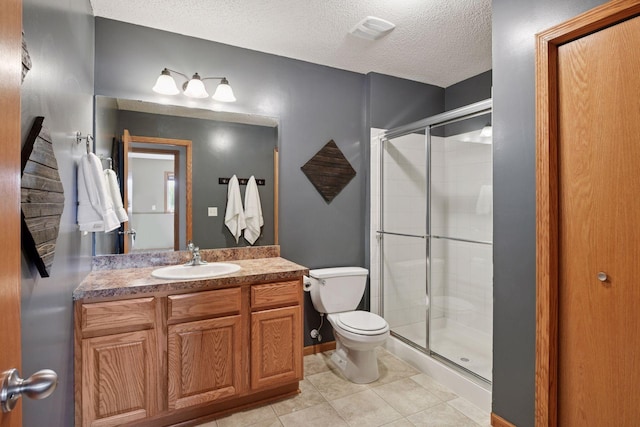 bathroom with toilet, a stall shower, a textured ceiling, tile patterned flooring, and vanity