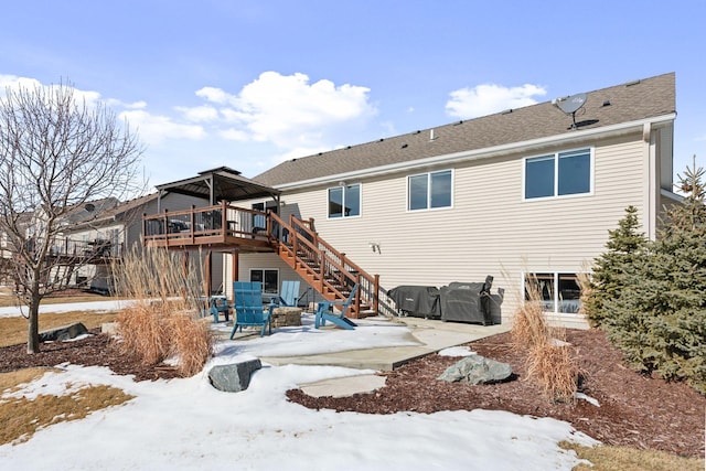 snow covered back of property featuring stairway, roof with shingles, a wooden deck, a gazebo, and a patio area