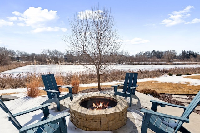 snow covered patio featuring a fire pit