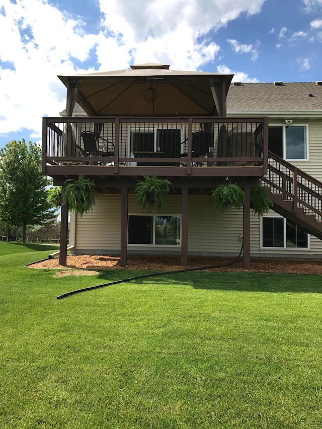 back of property with a deck and a yard