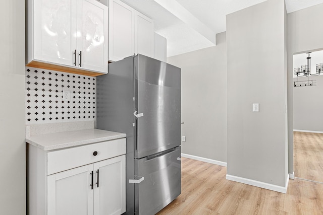 kitchen featuring white cabinets, light hardwood / wood-style floors, and stainless steel refrigerator