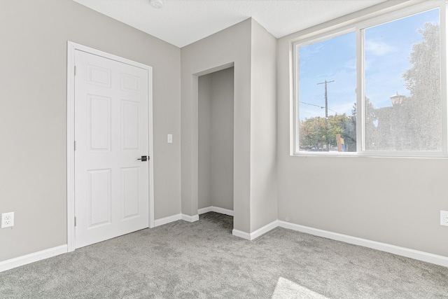 unfurnished bedroom featuring light colored carpet and a closet