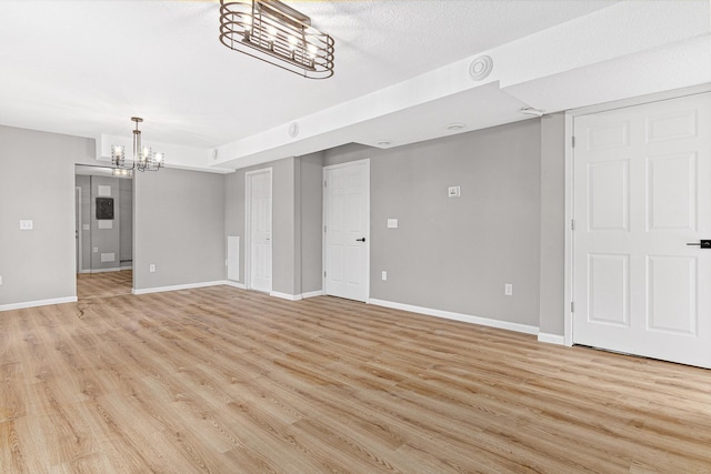 interior space featuring a notable chandelier, light hardwood / wood-style floors, and a textured ceiling