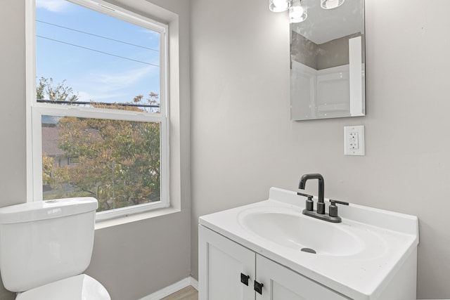 bathroom featuring vanity, a healthy amount of sunlight, and toilet