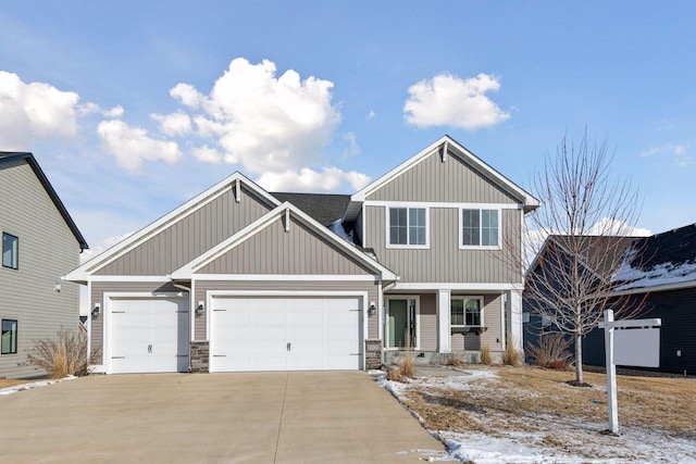 craftsman house featuring stone siding, a garage, and driveway