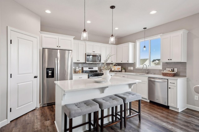 kitchen featuring backsplash, appliances with stainless steel finishes, dark wood-style flooring, and white cabinetry