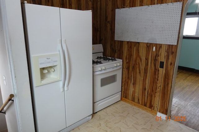 kitchen with wood walls and white appliances