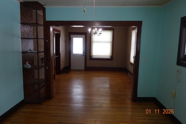 entryway with an inviting chandelier, ornamental molding, and dark hardwood / wood-style floors