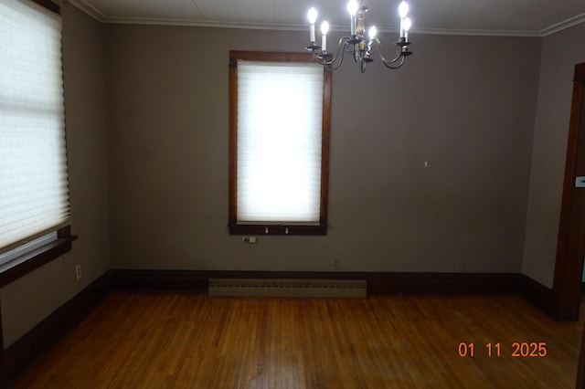 unfurnished room featuring wood-type flooring, a notable chandelier, crown molding, and a baseboard radiator