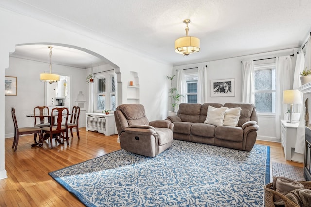 living room featuring a textured ceiling, crown molding, and wood-type flooring